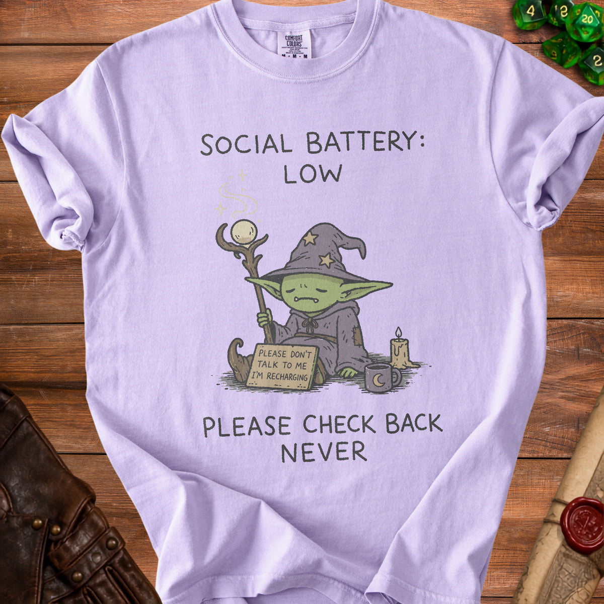 Light purple t-shirt with a goblin wizard graphic and text "Social Battery: Low" and "Please check back never".