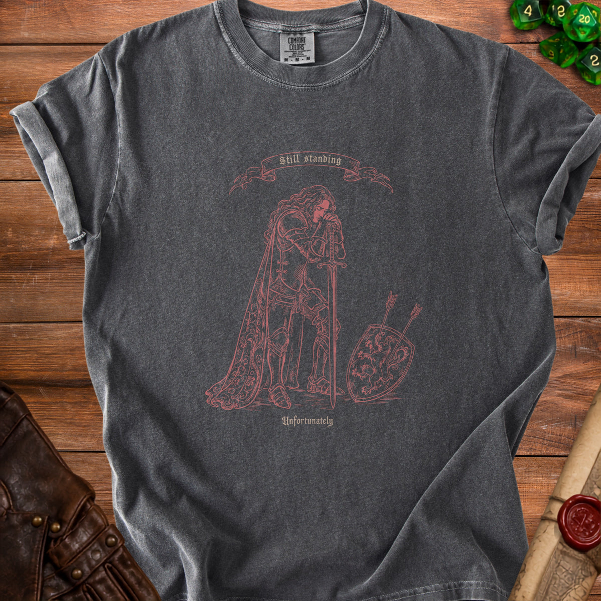 Dark grey t-shirt with "Still standing" and knight graphic that reads "Unfortunately".