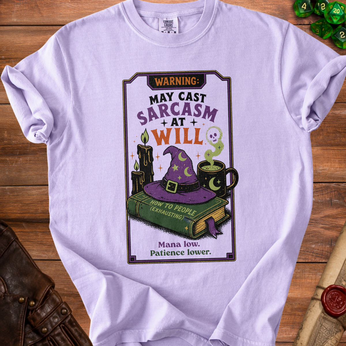 Lavender t-shirt with "WARNING: MAY CAST SARCASM AT WILL" text and witchy illustrations.