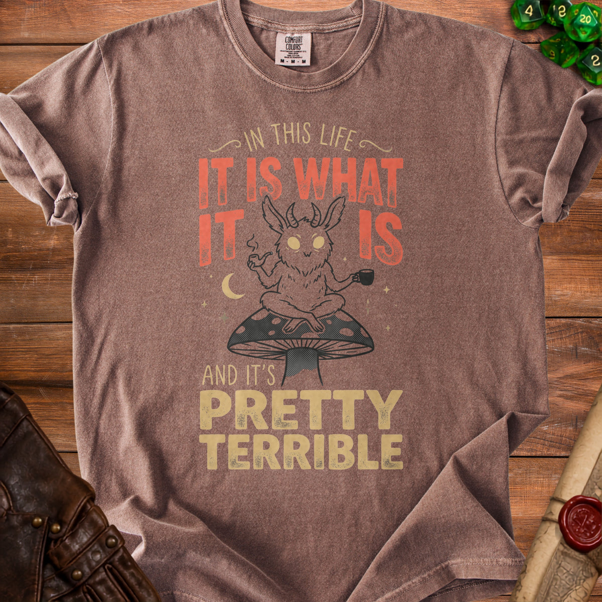 T-shirt with a creature on a mushroom, reading "It is what it is and it's pretty terrible."