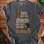 Dark grey t-shirt with text "I HAVE SEEN THE OMENS AND THEY ARE NOT MY PROBLEM".