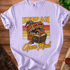 Light purple t-shirt with "Keep An Open Mind" and a monster chest graphic.