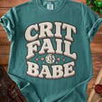 Teal t-shirt with "CRIT FAIL BABE" text, broken d20 die, and hearts.