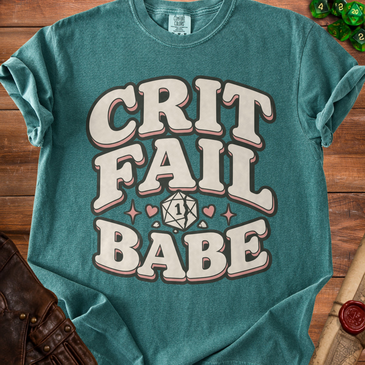 Teal t-shirt with "CRIT FAIL BABE" text, broken d20 die, and hearts.