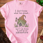 Pink t-shirt with cartoon gnome and text: "I don't know what lies ahead... but I do know it will be an adventure".