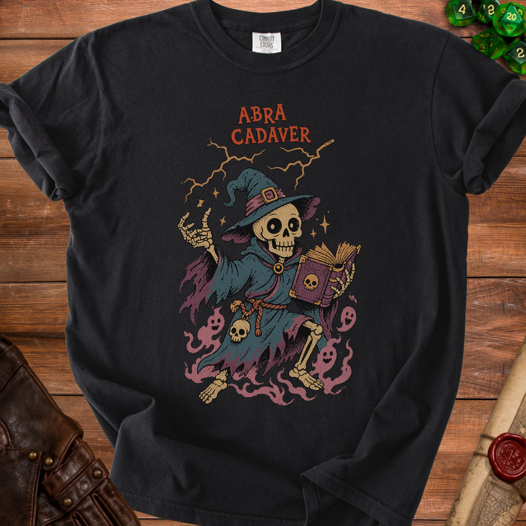 Skeleton wizard holding a spellbook, with text "ABRA CADAVER" above.