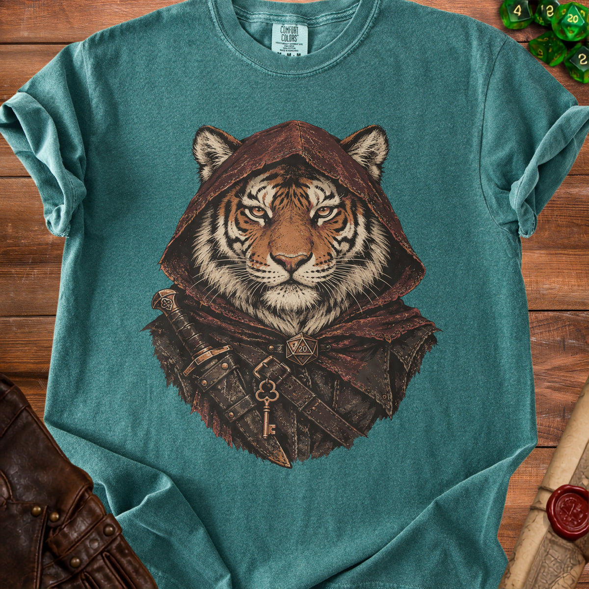 Teal t-shirt featuring a graphic of a tiger wearing a hooded cloak, dagger, and keys.