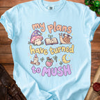 Light blue t-shirt with "my plans have turned to mush" text and whimsical illustrations.