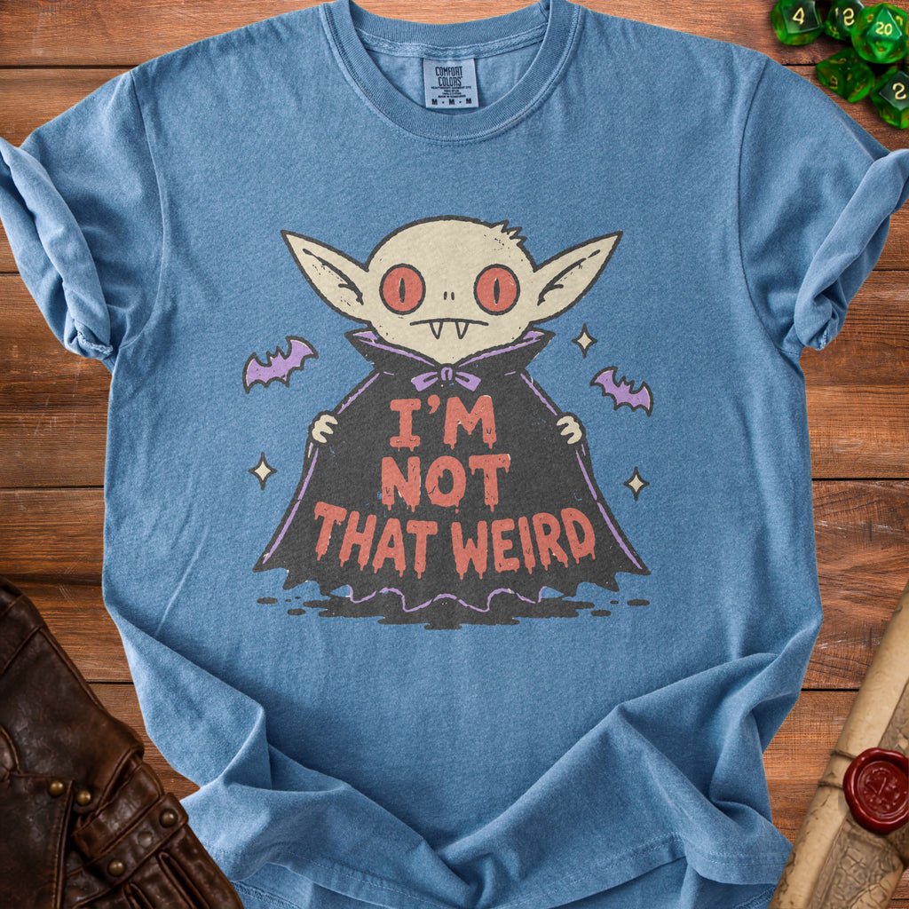 Blue t-shirt with a cartoon vampire design and text "I'M NOT THAT WEIRD".