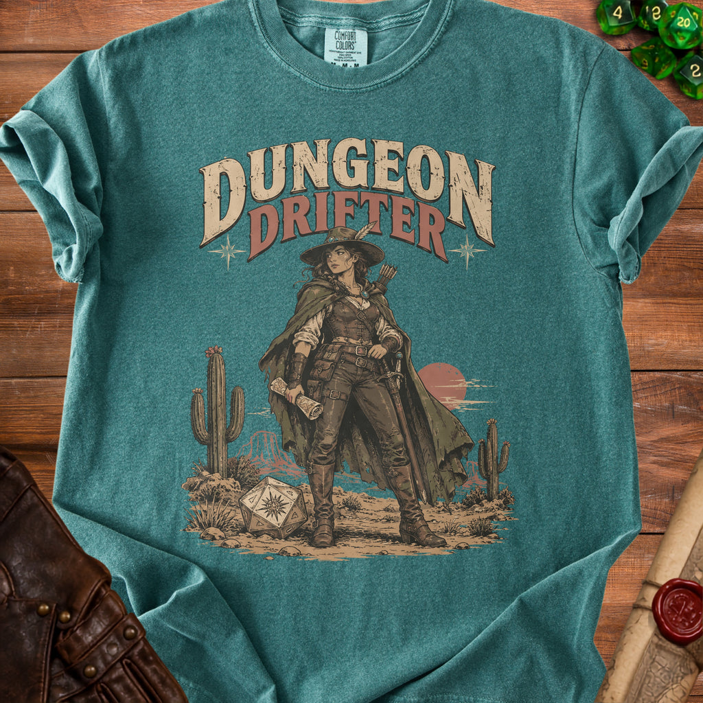 A teal crewneck t-shirt featuring a western graphic that says Dungeon Drifter with a character holding a map.