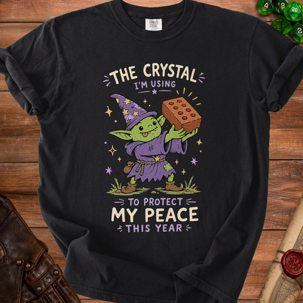 Black t-shirt with a goblin wizard graphic and text "The Crystal I'm Using to Protect My Peace This Year".