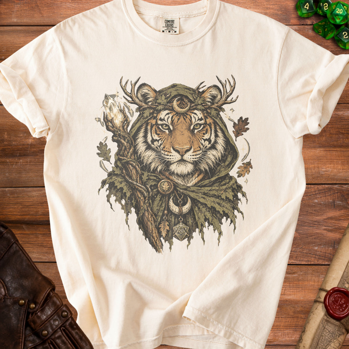 Cream t-shirt featuring a mystical tiger wearing antlers, a crescent moon, and holding a crystal staff.