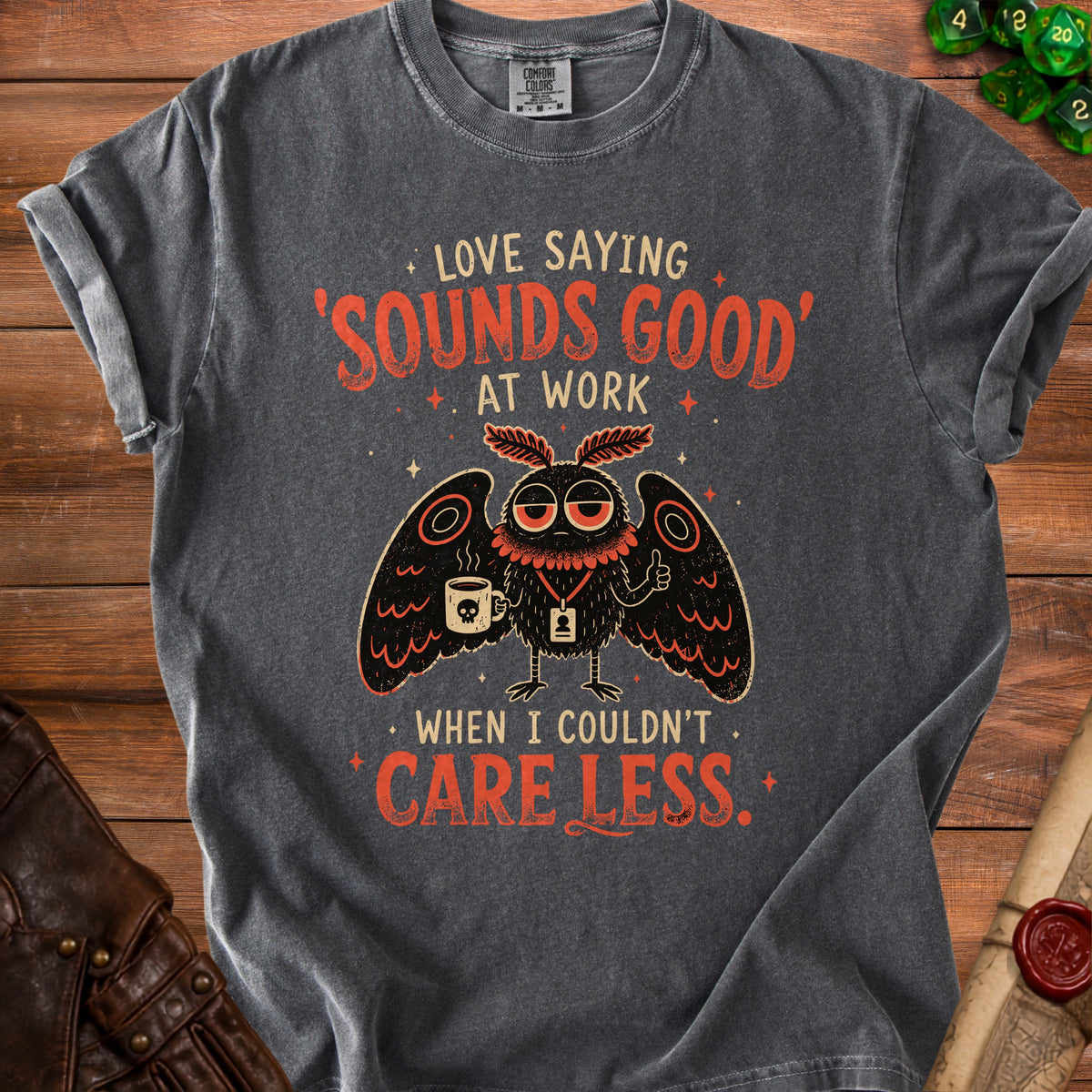 Dark grey t-shirt with moth graphic and text "Love Saying 'Sounds Good' At Work When I Couldn't Care Less."