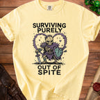Yellow t-shirt with skeleton graphic reading "Surviving Purely Out of Spite".