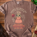 Brown t-shirt with a cartoon potato wearing a crown and pink dress, holding a poof, with text.