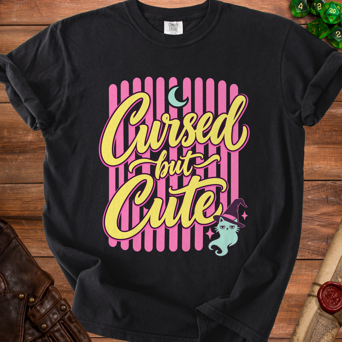 Black t-shirt with "Cursed but Cute" text and a cat wearing a witch hat.