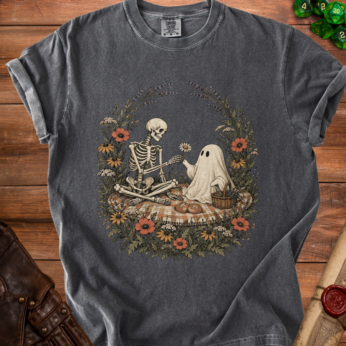 Skeleton and ghost share a flower on a picnic blanket surrounded by flowers.