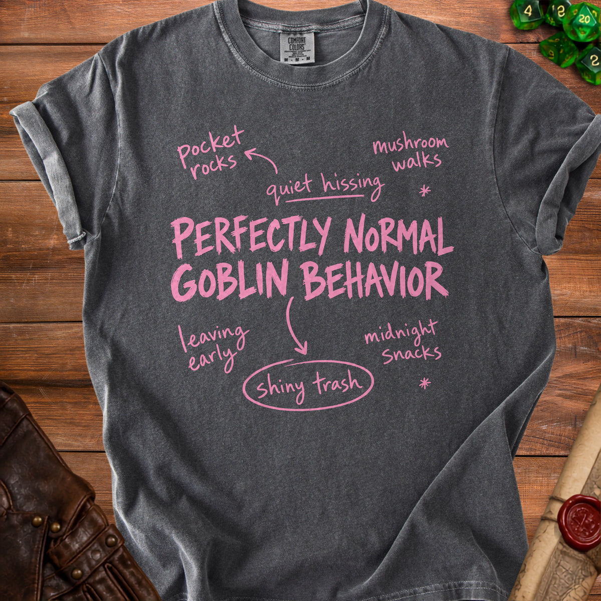 Charcoal t-shirt with "Perfectly Normal Goblin Behavior" and related phrases in pink.