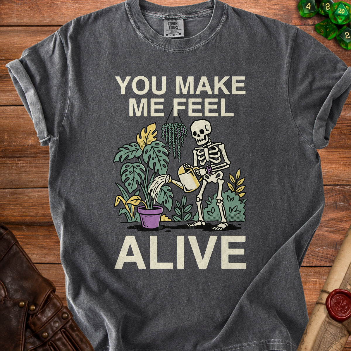 Skeleton watering plants with text "YOU MAKE ME FEEL ALIVE".