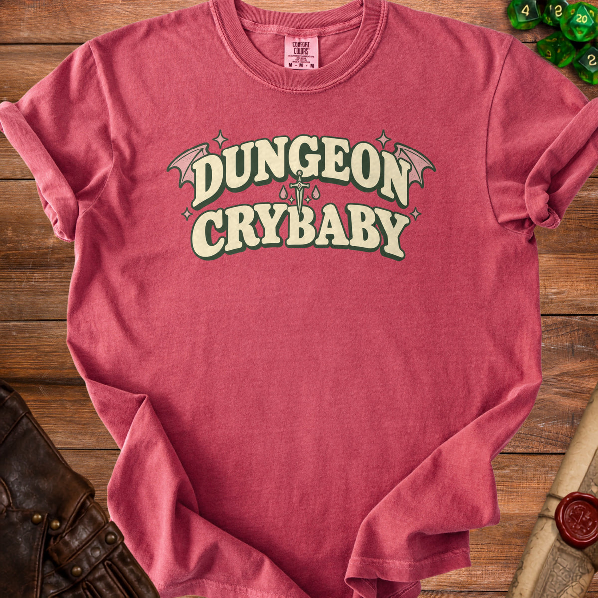 Red t-shirt with "Dungeon Crybaby" text, wings, sword, and tears design.