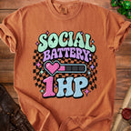 Orange t-shirt with "SOCIAL BATTERY: 1HP" text and pixelated heart.