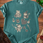 Green t-shirt with medieval fantasy cats, dice, and adventurer gear graphic.