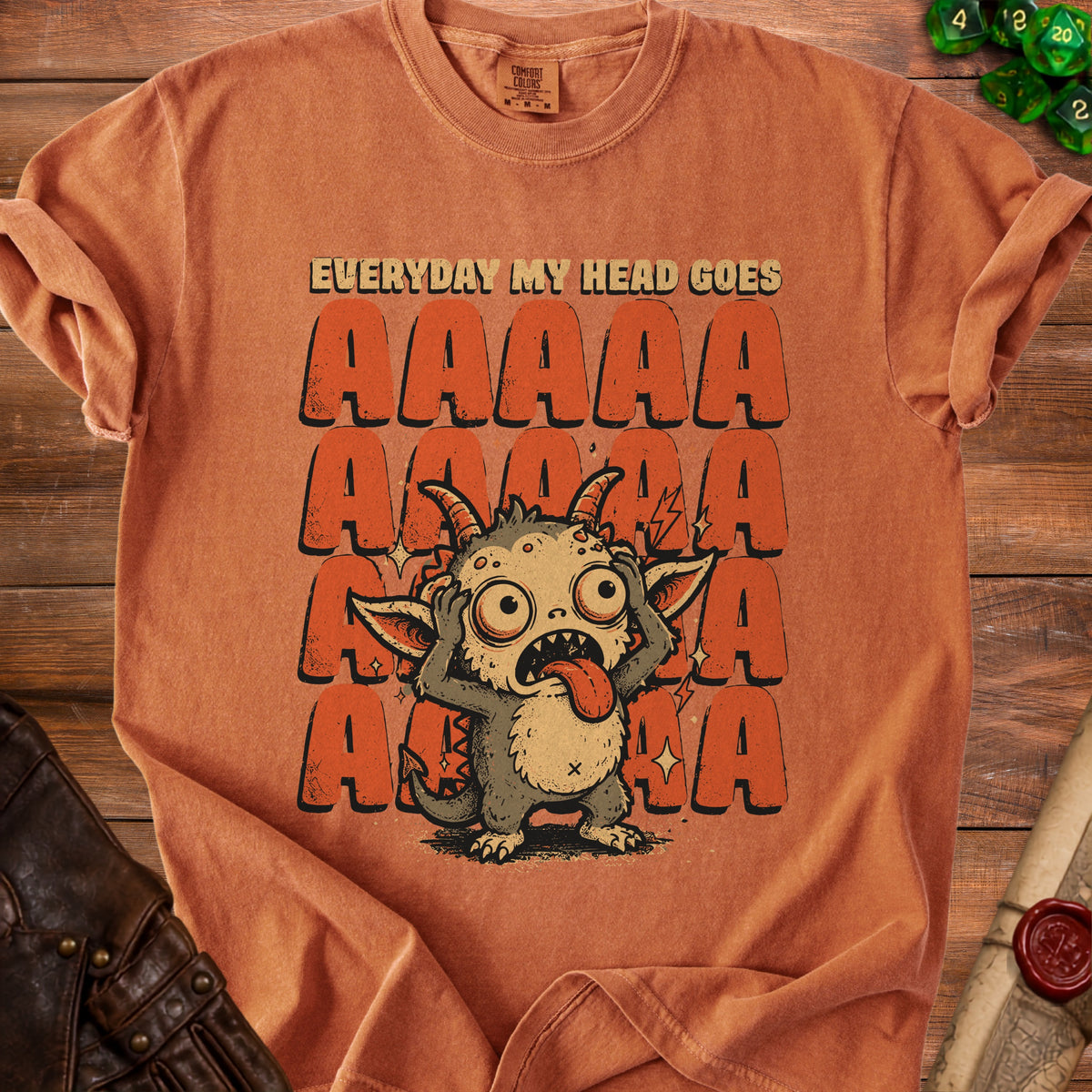 Orange t-shirt with distressed graphic of a monster and text "EVERYDAY MY HEAD GOES AAAAA".