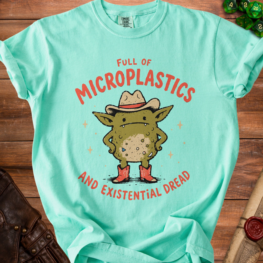 Mint green t-shirt with cartoon goblin wearing cowboy hat, red boots, and text "Full of Microplastics and Existential Dread".