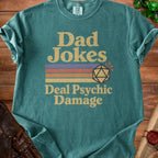 Teal t-shirt with "Dad Jokes Deal Psychic Damage" text and a twenty-sided die.