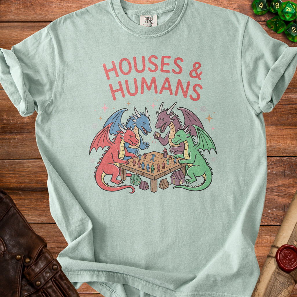 T-shirt with "HOUSES & HUMANS" and dragons playing a board game with figurines.
