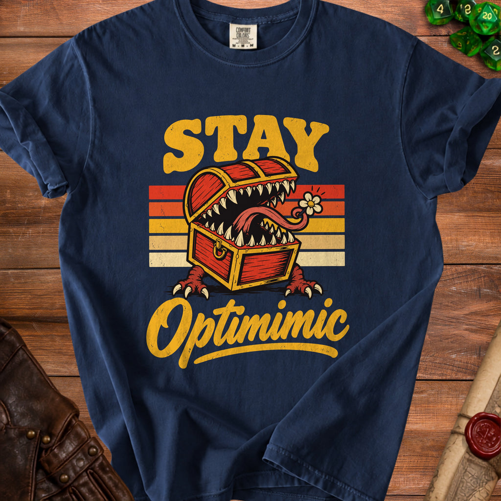 Navy t-shirt with vintage "STAY Optimimic" text and a monster treasure chest graphic.
