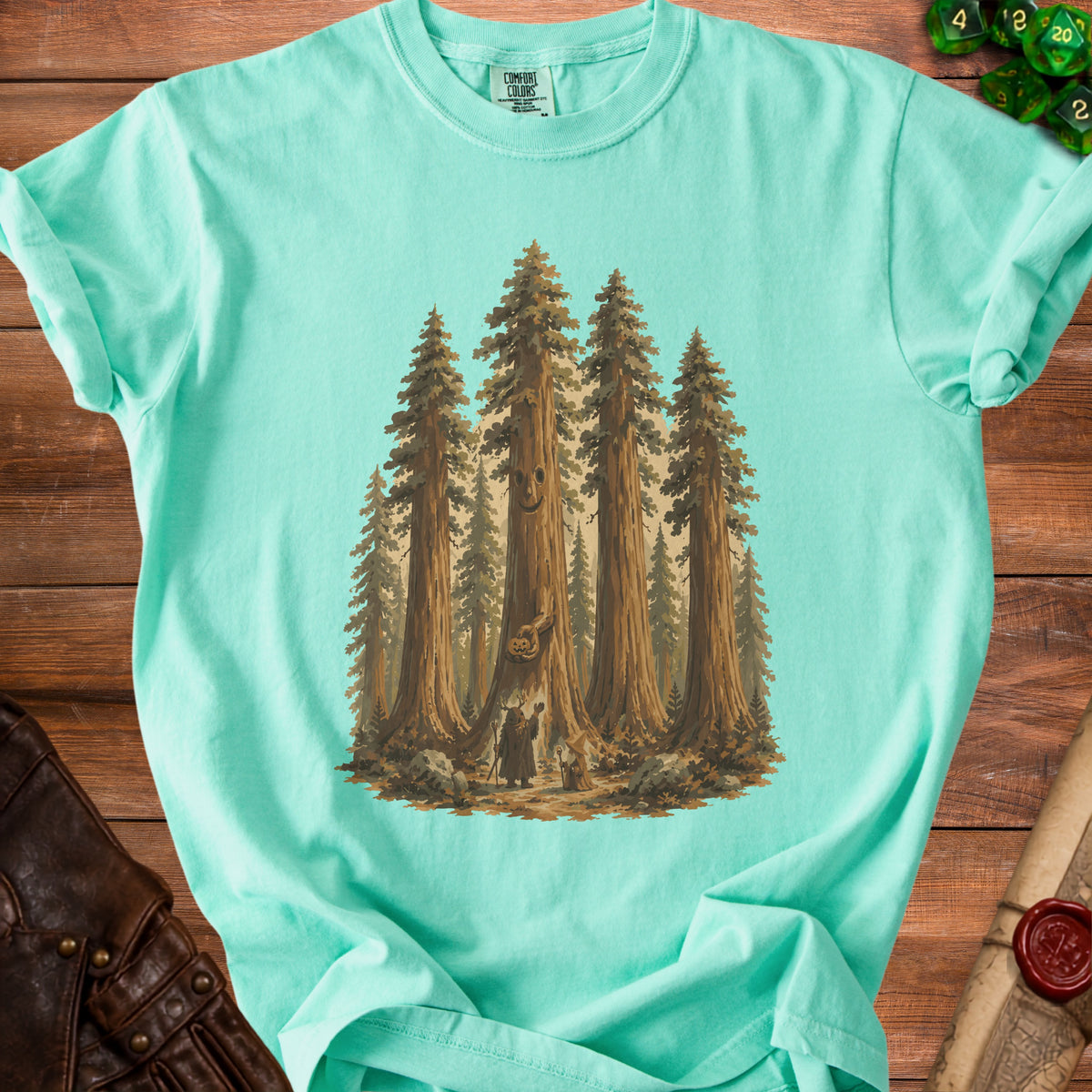 Teal t-shirt with illustration of figures in a redwood forest with a smiling tree.