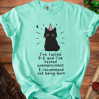 Mint t-shirt with cartoon black cat wearing party hat and text "I recommend not being born".