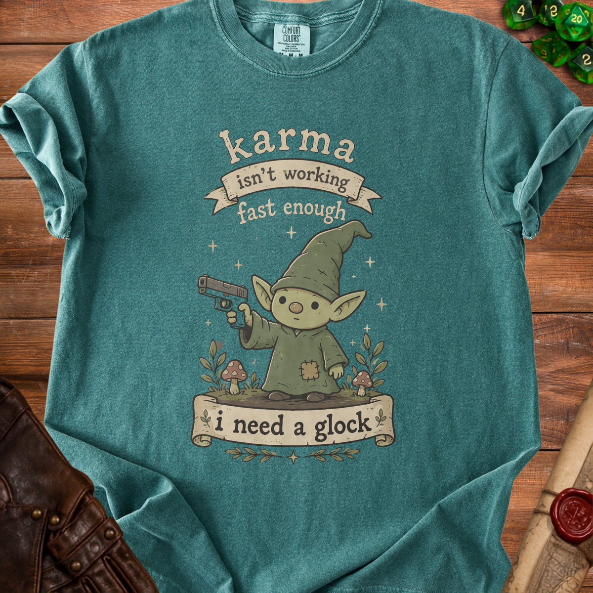Teal t-shirt with cartoon gnome holding a gun and text "karma isn't working fast enough i need a glock".