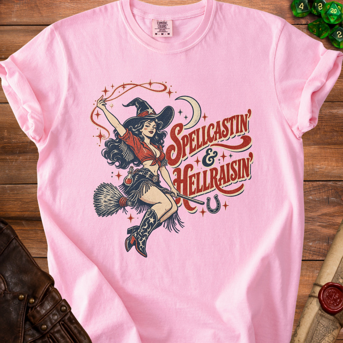 Pink t-shirt with witch graphic and text "Spellcastin & Hellraisin".