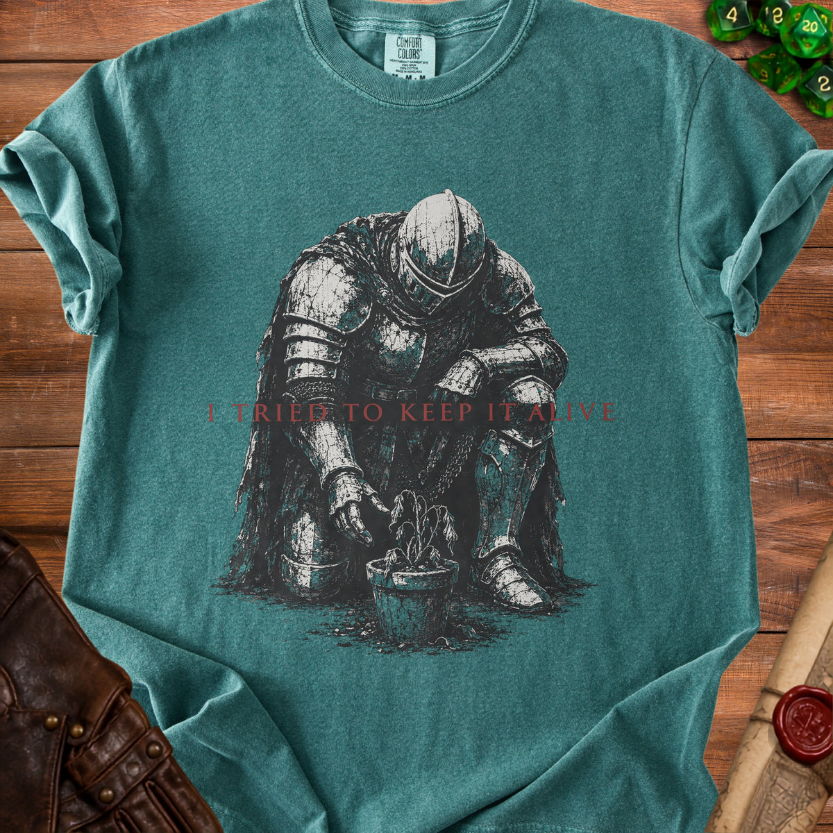 T-shirt graphic of knight kneeling by potted plant with text "I TRIED TO KEEP IT ALIVE".