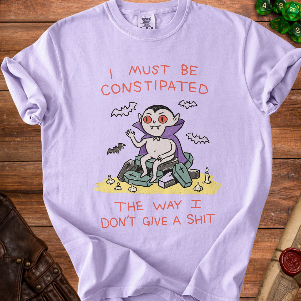 Lavender t-shirt with a cartoon vampire sitting on coffins and text.