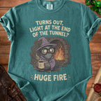 T-shirt with text "Turns out, light at the end of the tunnel? Huge fire." featuring a pigeon wizard.