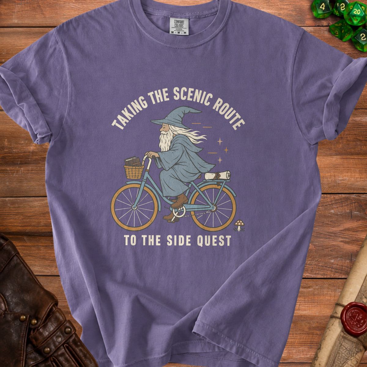 Purple t-shirt with wizard riding a bicycle, text: "Taking the Scenic Route to the Side Quest".
