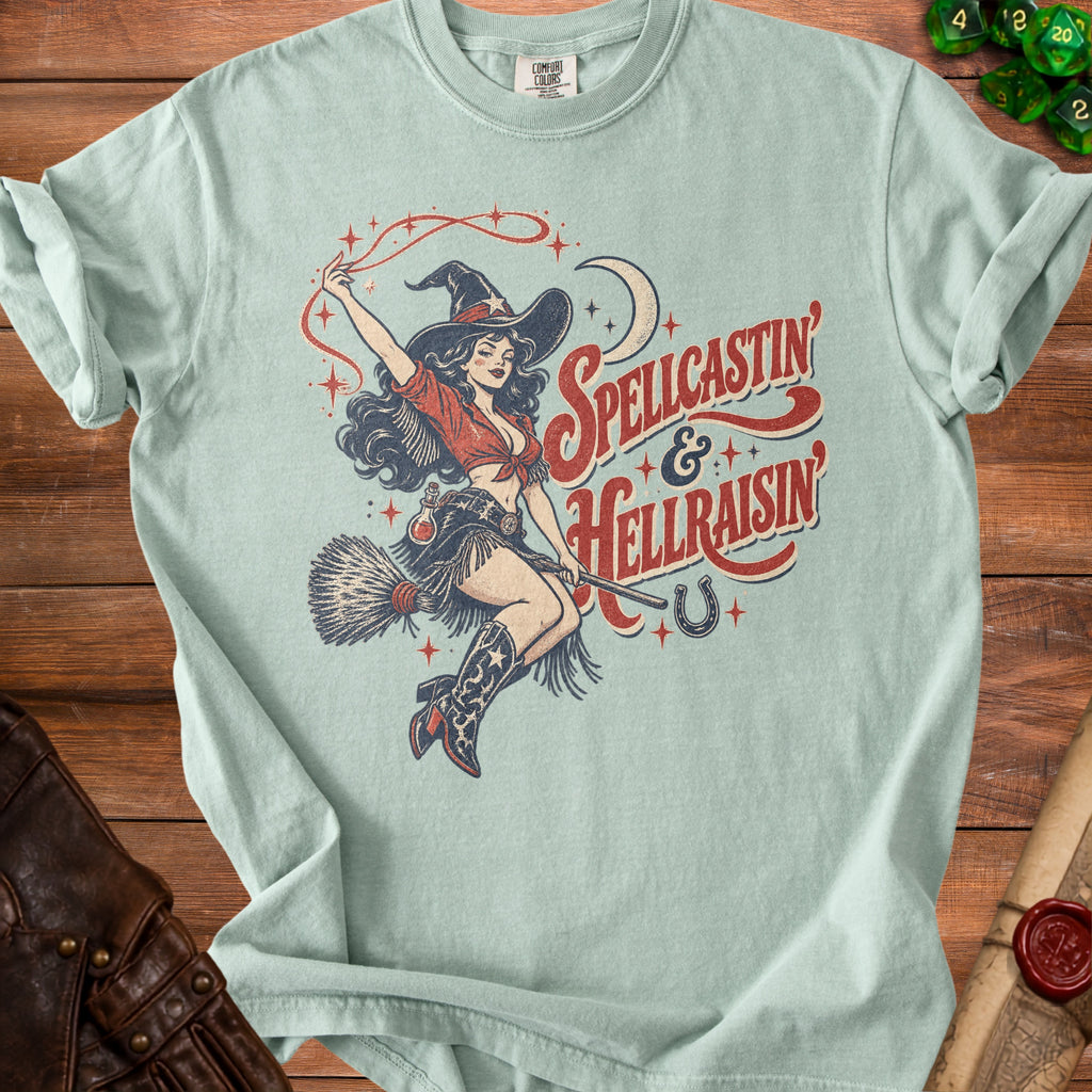 Light blue t-shirt with vintage pin-up witch graphic and "Spellcastin & Hellraisin" text.