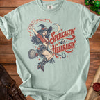 Light blue t-shirt with vintage pin-up witch graphic and "Spellcastin & Hellraisin" text.