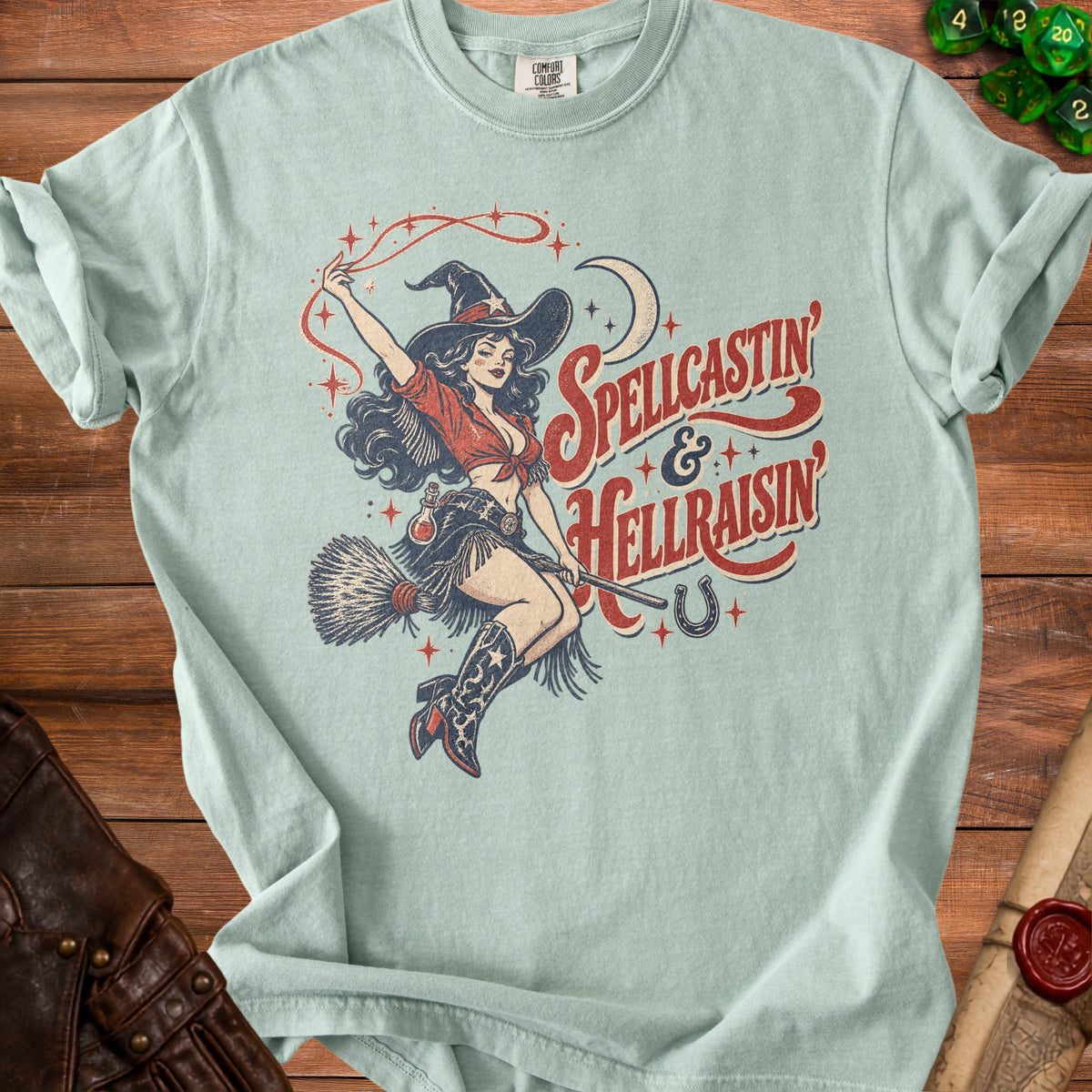 Light blue t-shirt with vintage pin-up witch graphic and "Spellcastin & Hellraisin" text.
