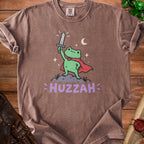 Brown t-shirt with graphic of a frog in a cape holding a sword, text reads "HUZZAH".