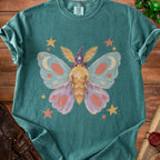 Teal t-shirt with a whimsical moth graphic wearing a wizard hat.