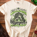 Cream t-shirt featuring "Summoning My Last Nerve" with a witch and occult imagery.