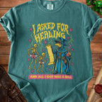 T-shirt with a plague doctor, skeletons, and text "I ASKED FOR HEALING AND ALL I GOT WAS A BILL".