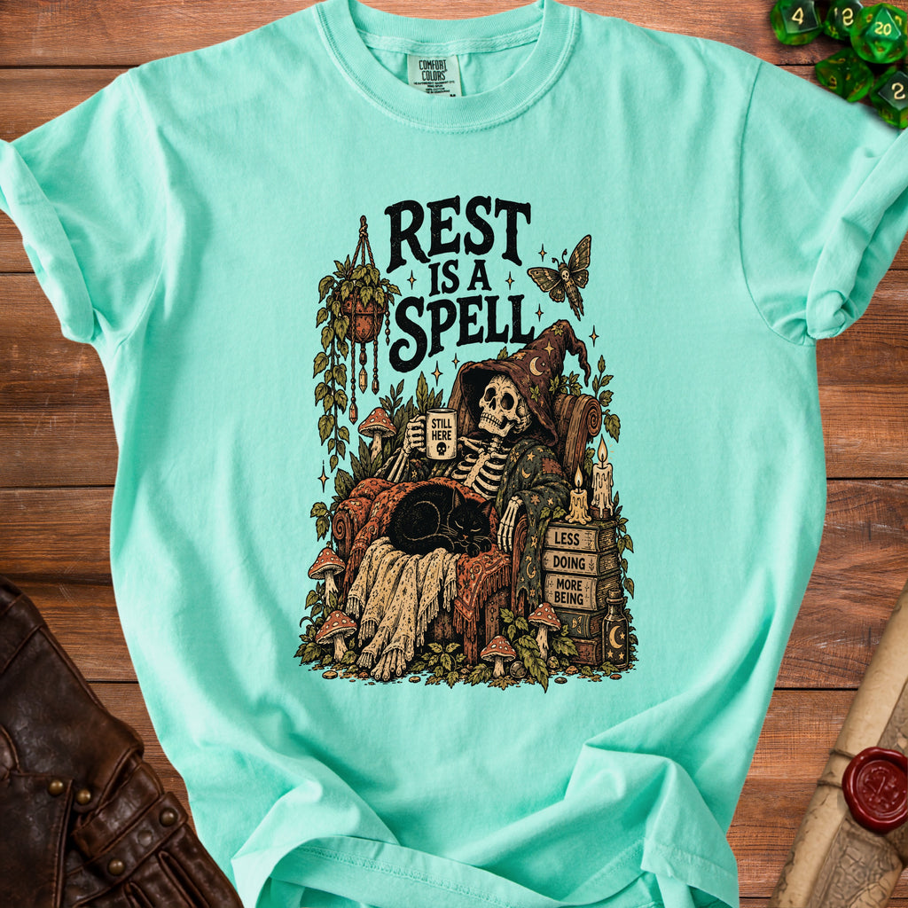Skeleton in witch hat reading with black cat, "Rest is a Spell" text.