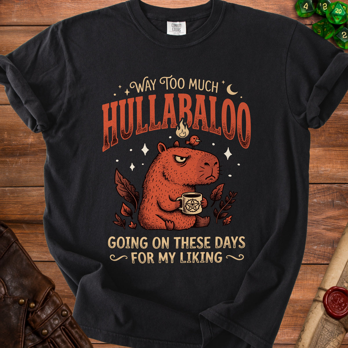 Black t-shirt with capybara holding pentagram mug, text reads "Way too much hullabaloo".
