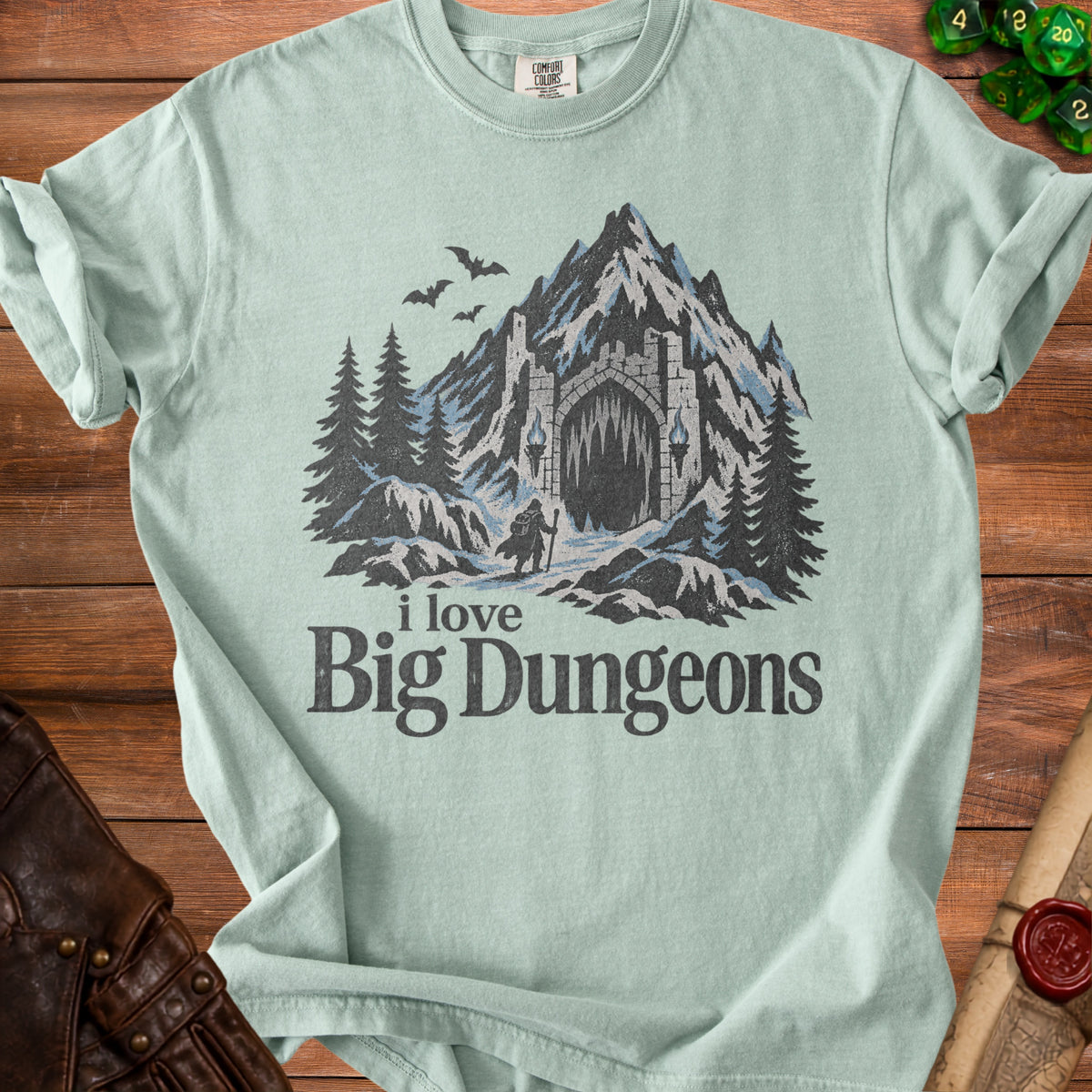 Light green t-shirt with "i love Big Dungeons" text and dungeon mountain graphic.