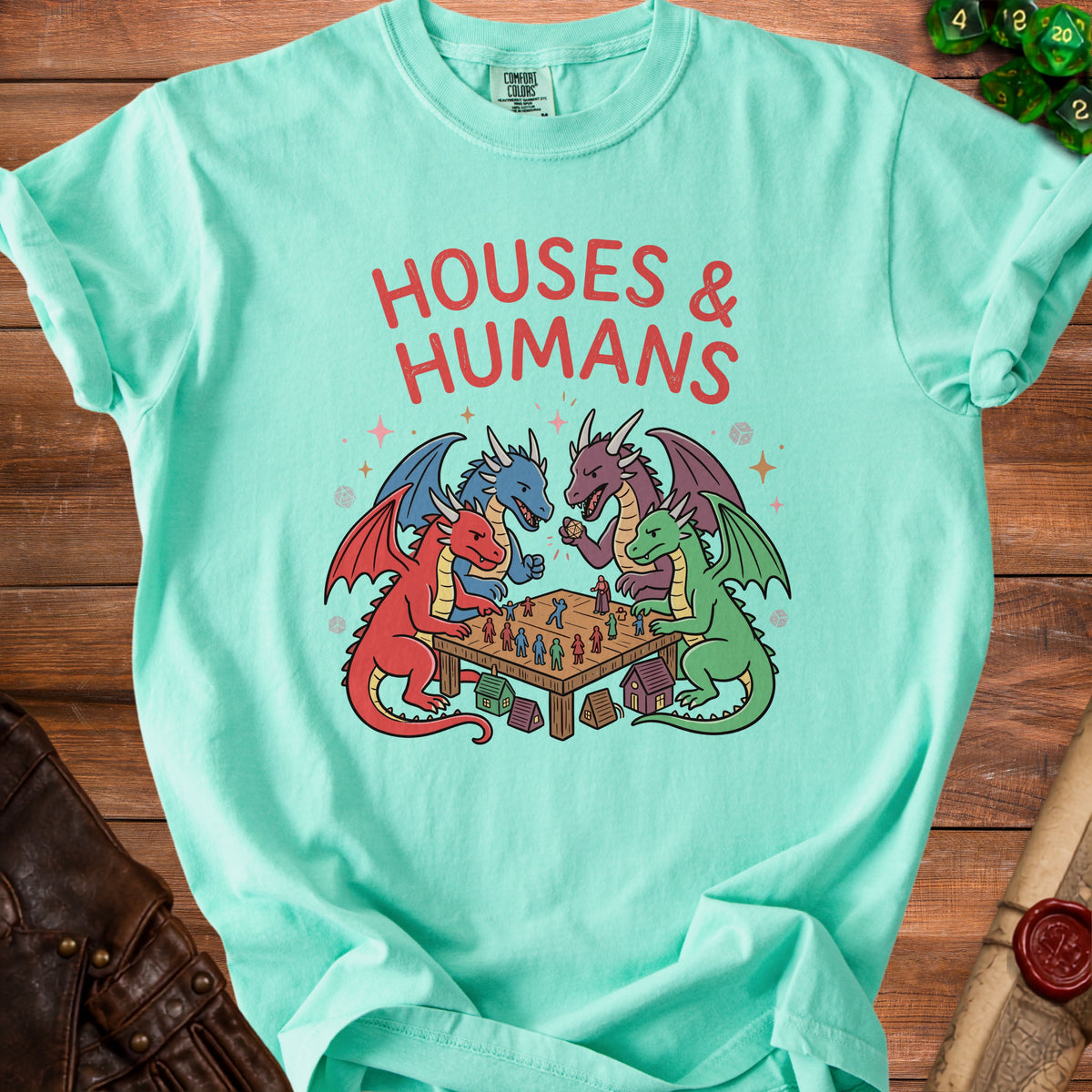 Teal t-shirt with four dragons playing a board game with tiny figures and houses.